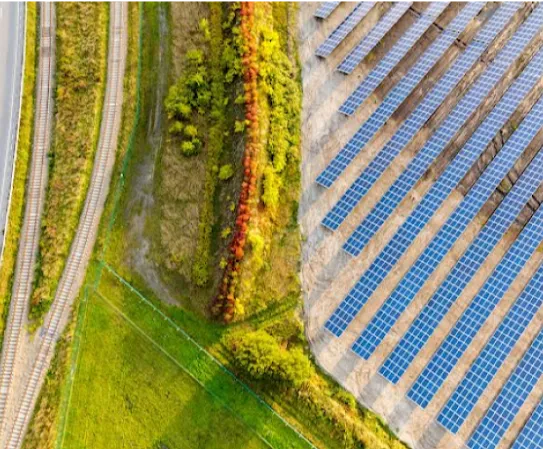 A green field and access road next to a solar farm